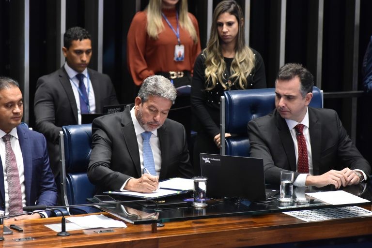 Arthur Lira assina o ato de promulgação, ao lado de Rodrigo Pacheco, presidente do Senado - (Foto: Zeca Ribeiro/Câmara dos Deputados)